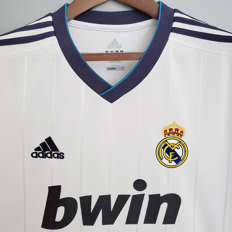 camisa-real-madrid-12-13-versão-retrô-branco-gola-v-brilhante-detalhe-adidas-azul-climacool-bordado-frente-costas-fundo-branco-cabide