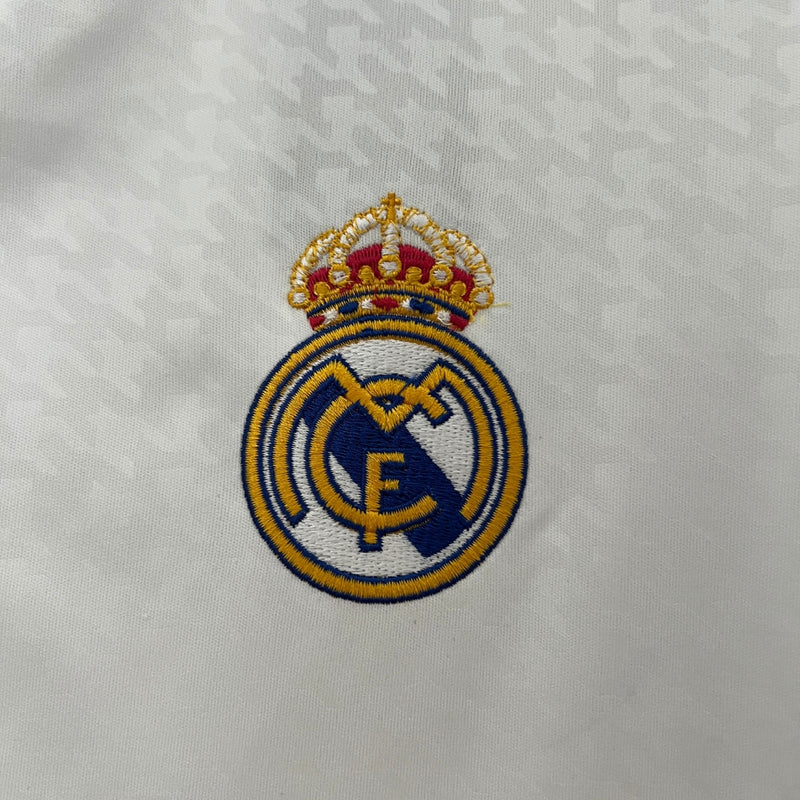 camisa-real-madrid-I-titular-24-25-versao-torcedor-branca-listras-pretas-gola-v-mbappe-vini-jr-rodrygo-bellingham-lançamento-poliester-cabide-fundo-braco-frente-costas-bordado