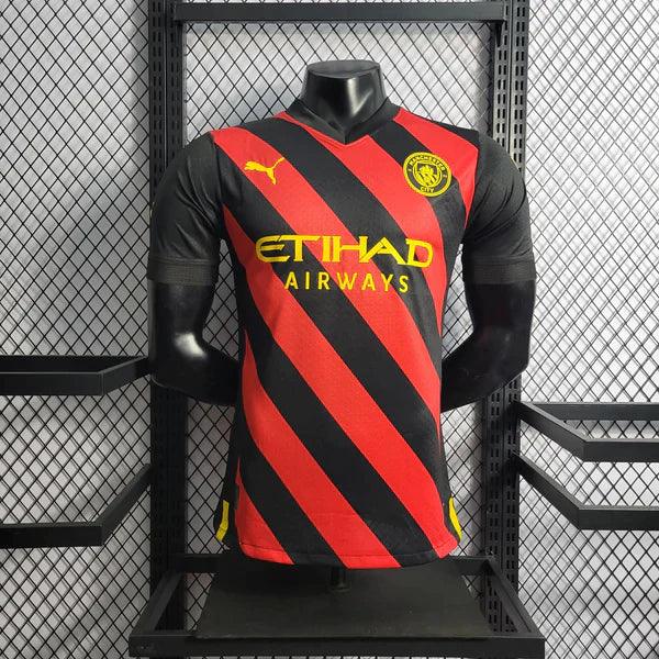 camisa-manchester-city-away-22-23-versão-jogador-puma-vermelho-preto-amarelo-manequim-fundo-grade