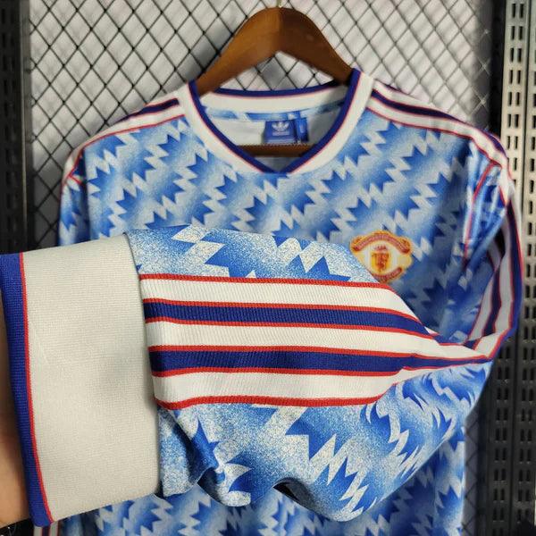 camisa-manchester-united-manga-longa-retrô-away-1990-1992-azul-listras-branca-punho-eslastico-gola-v-bordado-fundo-grade