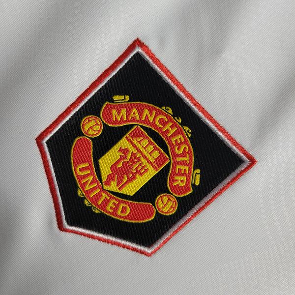 camisa-manchester-united-feminina-2023-2024-branca-gola-v-detalhada-vermelho-preto-adidas-grade-ao-fundo-away-reserva-bordado