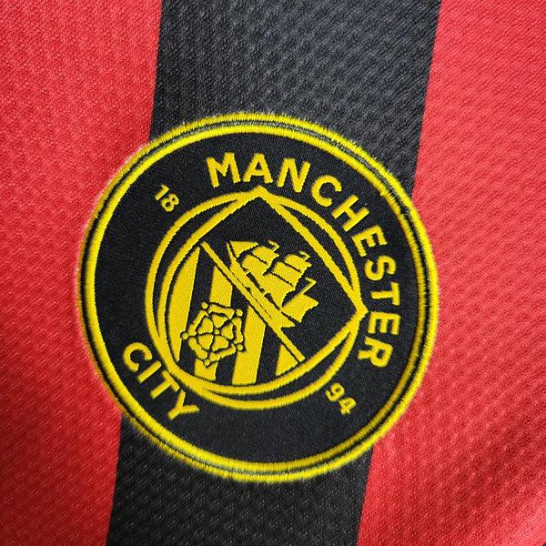 camisa-manchester-city-away-22-23-vermelho-preto-amarelo-gola-v-bordado